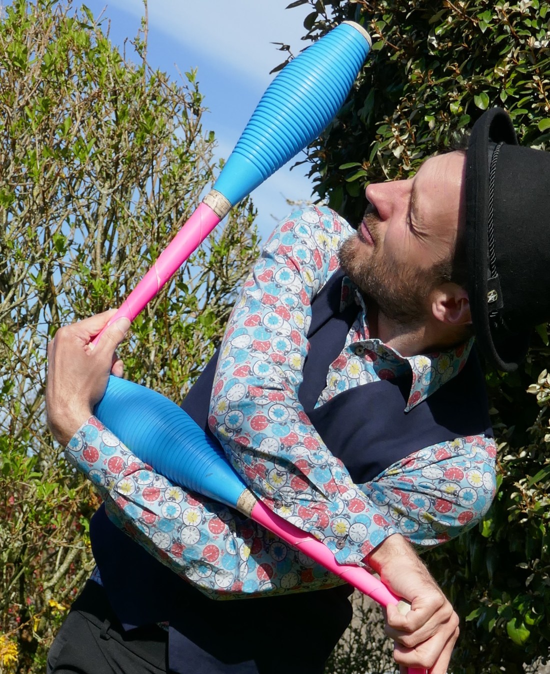 Artiste de cirque dans une posture étrange avec des massues, comme si elles étaient vivantes.